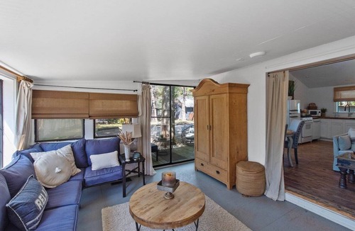 Shreveport Cabin | Emerald Cottage offers a laid-back stay surrounded by towering trees, with a spacious deck, kayaks and canoes to paddle through the cypress forest, and a firepit perfect for slow evenings outside.