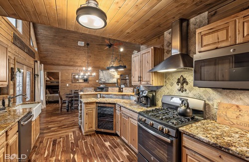 Shreveport House | Relax at this lakefront log cabin on private Emerald Isle, designed for easy outdoor living. Enjoy the hot tub, paddle out with kayaks and canoes, gather around the fire pit, or grill and unwind by the water.